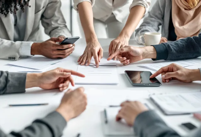 Hands pointing at documents during a planning meeting